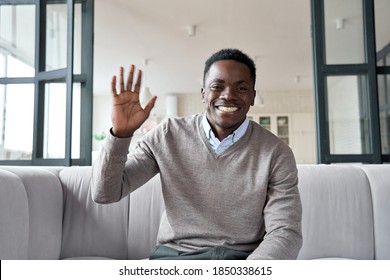 Happy african young man online teacher, coach, distance worker waving hand looking at camera or web cam video conference calling in virtual webcam chat meeting by remote video call. Headshot portrait.