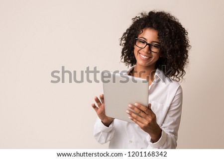 Happy african-american businesswoman using digital tablet over light background, copy space