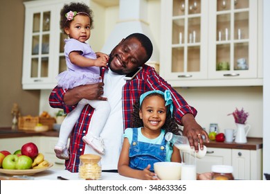 Happy African-American Man Making Breakfast For His Daughters