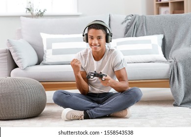 Happy African-American Teenager Boy Playing Video Games At Home