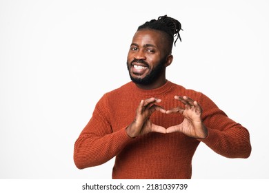 Happy african-american young man with dreadlocks in red sweater showing heart-shape gesture for love passion care isolated in white background