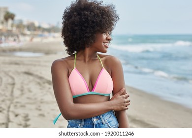 Fröhliche Afro-Amerikanerin, die auf das Meer schaut