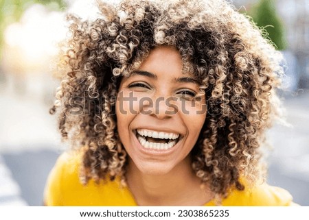 Happy afro american young woman smiling at camera outside - Close up portrait of brazilian female laughing on city street - Life style and positive vibes people concept