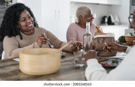 Happy Afro Latin Family Eating Healthy Lunch With Fresh Vegetables At Home - Food And Parents Unity Concept