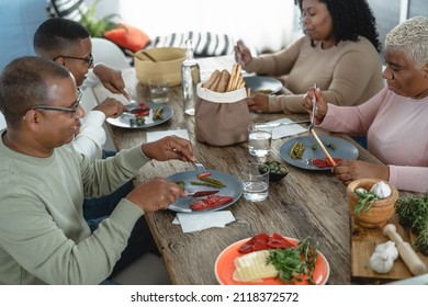 Happy Afro Latin Family Eating Healthy Lunch With Fresh Vegetables At Home - Food And Parents Unity Concept