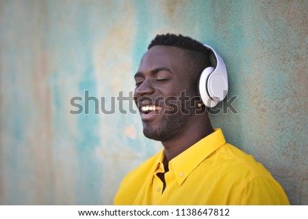 Young happy black man is listening to music