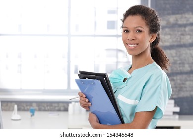 Happy afro medical worker holding case sheets, smiling. - Shutterstock ID 154346648