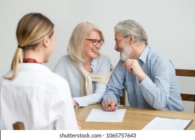 Happy Aged Couple Talking Laughing Ready To Sign Document At Meeting, Senior Retired Clients Buying Medical Health Life Insurance, Older Family Make Deposit Investment In Bank With Financial Advisor