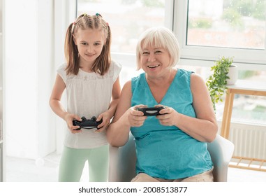 Happy Aged Woman Playing Video Game With Granddaughter