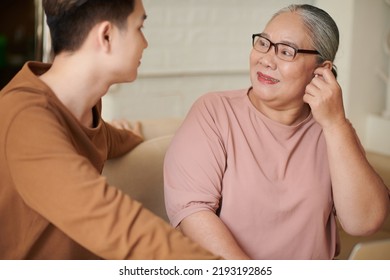 Happy Aged Woman Putting In Earbuds Grandson Presented Her For Birthday