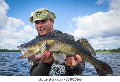 Happy angler with old walleye fish