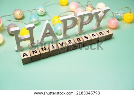 Happy Anniversary alphabet letter with LED cotton balls on green background