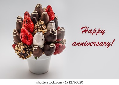 Happy Anniversary Greeting Card With Red Lettering; A Bunch Of Edible Flowers, Arrangement Of Chocolate Dipped Strawberries Isolated On White Background