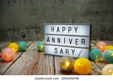 Happy Anniversary Text On Lightbox On Wooden Background