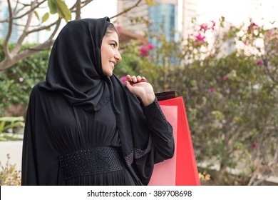 Happy Arab Emirati Woman With Shopping Bags Outdoor