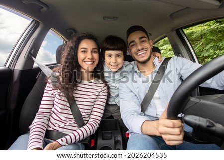 Happy Arab Family With Little Son Sitting Inside Of Car And Smiling At Camera, Cheerful Middle Eastern Parents With Cute Male Kid Enjoying Road Trip In Their New Automobile, Closeup Shot