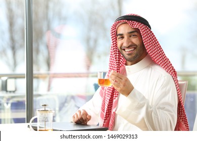 Happy Arab Man Holding A Cup Of Tea Looking At Camera Sitting In A Coffee Shop