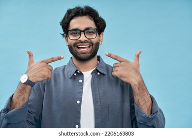 Happy Arab Man Pointing Fingers At Healthy White Teeth Advertising Dentist Services Or Dental Care Product Commercial Promo, Presenting Perfect Smile Standing Isolated On Blue Background.