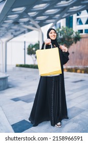 Happy Arab Woman Shopping Carrying Bags. Arabian Muslim Lady Excited In Sale Wearing Abaya Outdoor In Mall