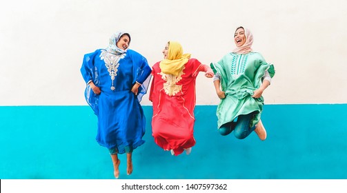 Happy Arabian Women Friends Having Fun Together Outdoor - Young Islamic Girls Jumping And Laughing - Friendship, Youth, Ethnic Culture And Religion Concept - Main Focus On Center Girl Face