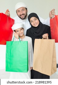 Happy Arabic family with mall shopping bags