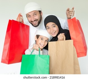 Happy Arabic family with mall shopping bags