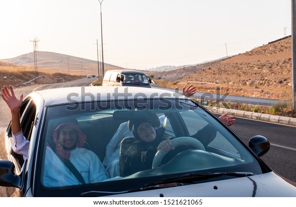 happy arabic family outside the car window waving\
at each other