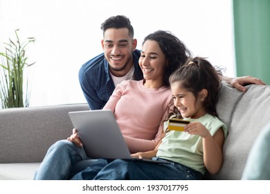 Happy Arabic Family Using Digital Tablet And Credit Card For Online Shopping