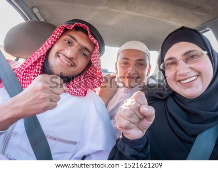 Happy arabic muslim family at their car on a trip together