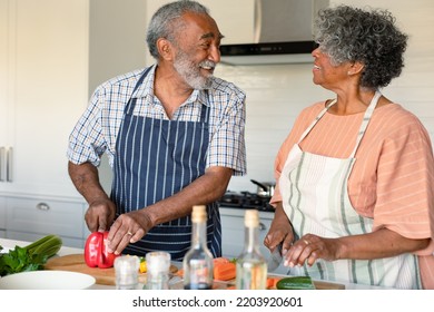 Happy arfican american senior couple cutting vegetables and preparing meal together. healthy retirement lifestyle at home. - Powered by Shutterstock