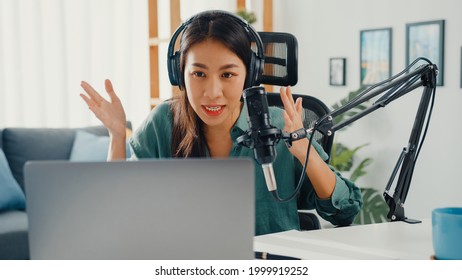 Happy Asia Girl Record A Podcast On Her Laptop Computer With Headphones And Microphone Talk With Audience At Her Room. Female Podcaster Make Audio Podcast From Her Home Studio, Stay At House Concept.