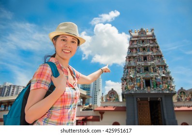 Happy Asia woman Travel in Singapore, Pointing Sri Mariamman Temple