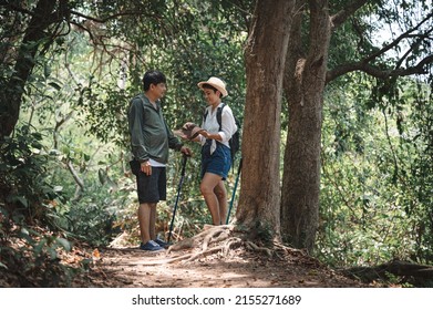 Happy Asian Adult Couple Trekking In The Wood	