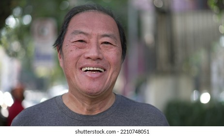 Happy Asian American senior man smiling at camera while walking outdoors. Excited middle aged Japanese person walks in urban street sidewalk - Shutterstock ID 2210748051