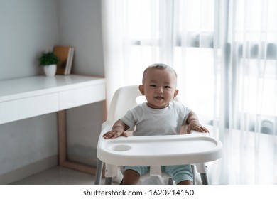 Happy Asian Baby Boy Sitting On High Chair Smiling