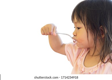 Selective​ Focus​ Of​ Happy Asian Baby Child Girl​eating Yogurt Food By Herself. Her Face Is Sloppy And Messy. 2-3​ Years​ Old​ Baby.​ On White Background Isolated. Kid And Food Concept.