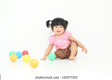 Happy Asian Baby Girl With Thai Traditional Dress Playing With Colorful Ball On White Isolate