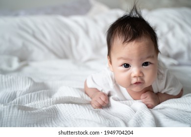 Happy Asian Baby Infant Learning To Crawl On White Soft Bed. 3 Months Old Baby Facial Expression. Lovely And Smile Baby. Cute Kid Looking At Camera..