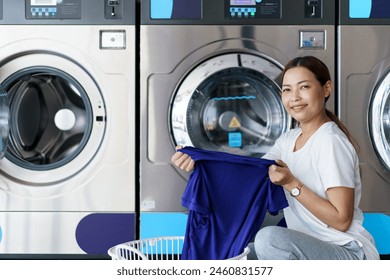 Happy Asian beautiful woman using a self service washing machine KIOSK or automatic washing machine vendor. Woman interacting with a self-service laundry machine at convenience store. - Powered by Shutterstock