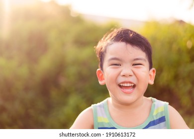 Happy Asian Boy Child Showing Front Teeth With Smile And Laughing : Healthy Happy Funny Smile Face Kid.Adorable Toddler Mixed Race Kid.portrait Asian Boy At The Park.Summer.pediatric Kid Clinic.