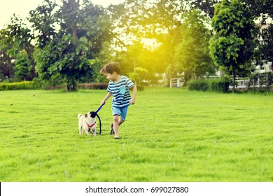 Happy Asian Boy Playing With His Dog In Garden