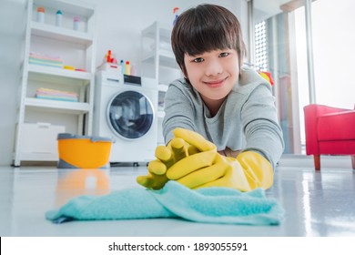 Happy Asian Boy With Rubber Gloves Is Cleaning Up The Floor, Helping Family With Housework.