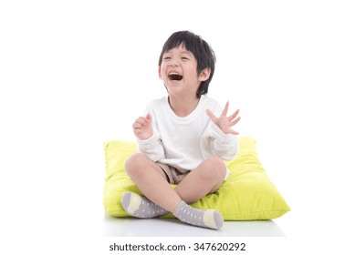 Happy Asian Boy Sitting On White Background Isolated