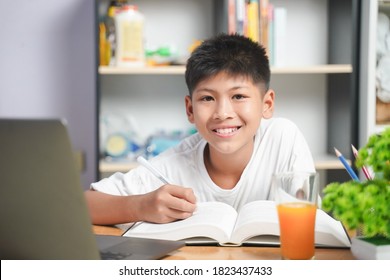 Happy Asian boy student online learning with laptop at home. class study online video call. Social distance, home schooler, New normal, Covid-19, Stay home. - Powered by Shutterstock