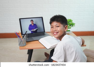 Happy Asian boy student online learning with laptop at home. class study online video call. Social distance, home schooler, New normal, Covid-19, Stay home. - Powered by Shutterstock