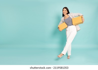 Happy Asian business woman holding package parcel box isolated on green background, Delivery courier and shipping service concept - Shutterstock ID 2119581353