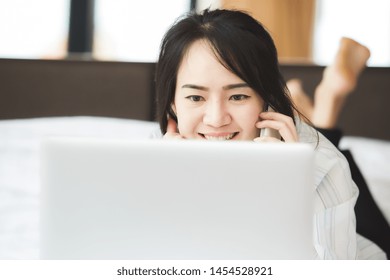 Happy Asian Business Woman Talking With Cell Phone Laying Down On The Bed.