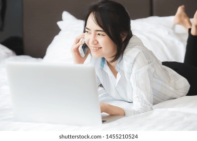 Happy Asian Business Woman Talking With Cell Phone Laying Down On The Bed.