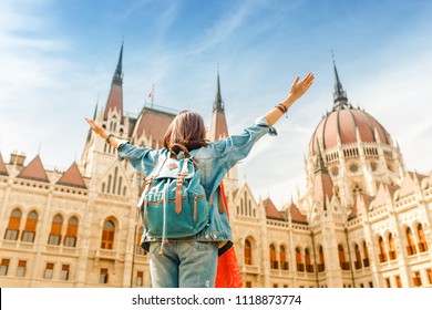 Happy asian casual woman student enjoying great view of the Parliament building in Budapest city, travel in Europe concept