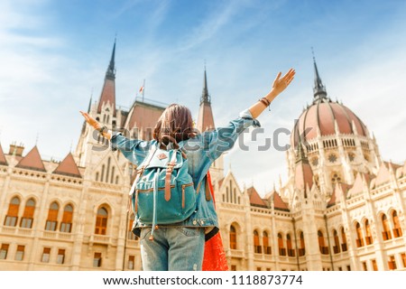 Happy asian casual woman student enjoying great view of the Parliament building in Budapest city, travel in Europe concept